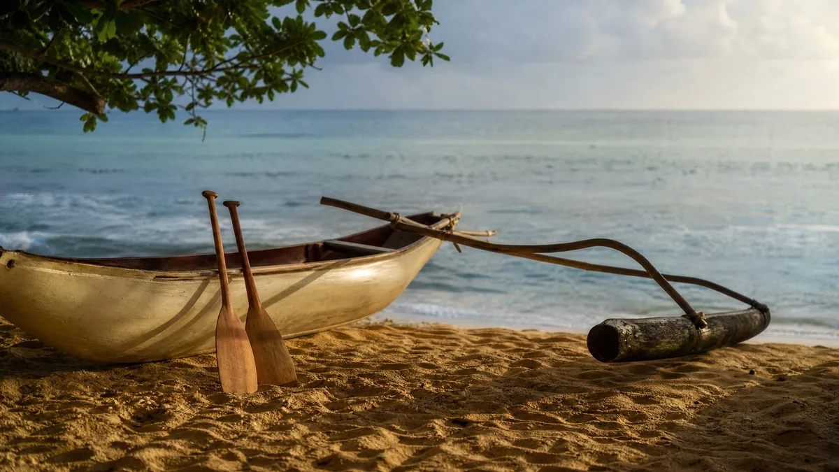 A traditional outrigger canoe resting on golden sand with its paddles, calm water behind