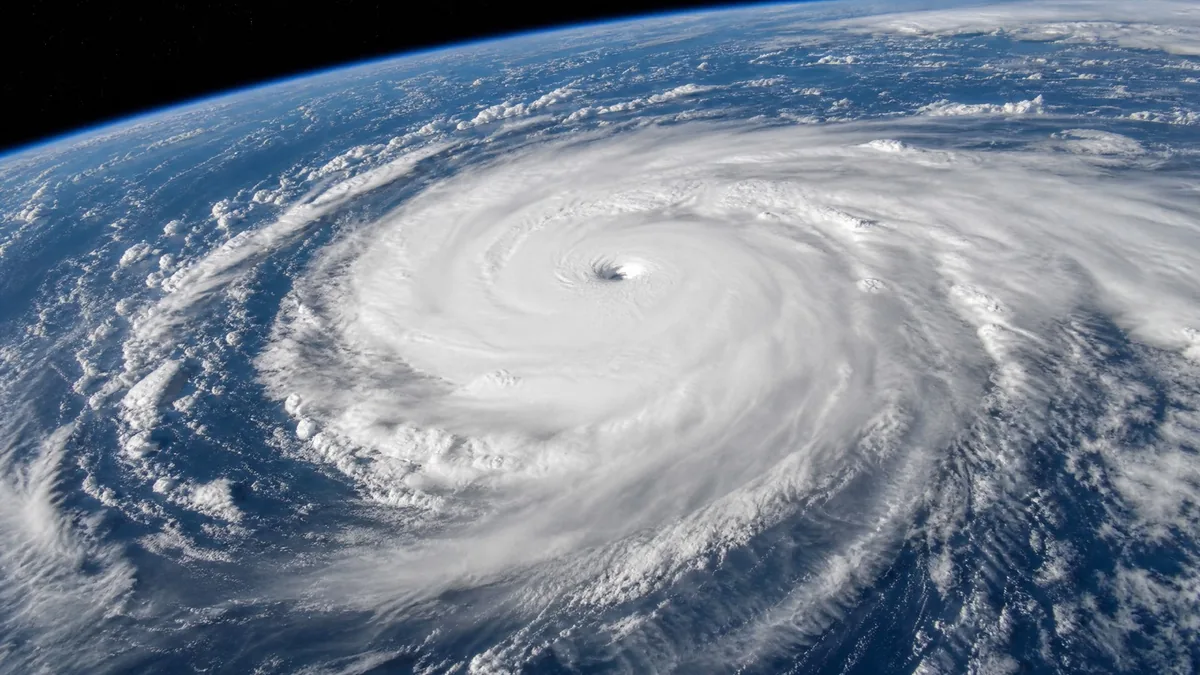 A swirling tropical cyclone seen from space over a blue ocean