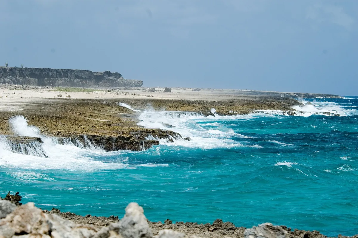 Turquoise waves breaking on the rocky limestone shore of Washington Slagbaai National Park, Bonaire
