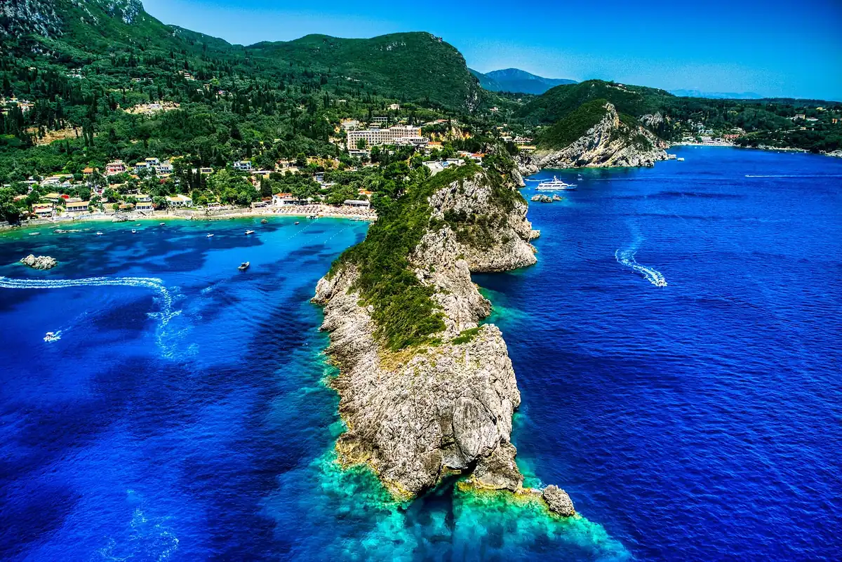 Aerial view of the forested headland and deep blue bays of Paleokastritsa on Corfu's west coast