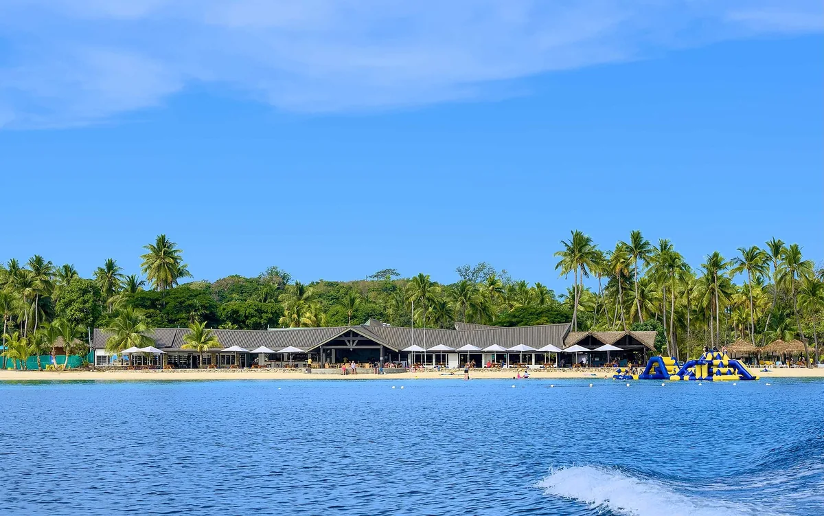Palm-backed beach and resort buildings on Malolo Lailai in Fiji's Mamanuca Islands, seen from the water
