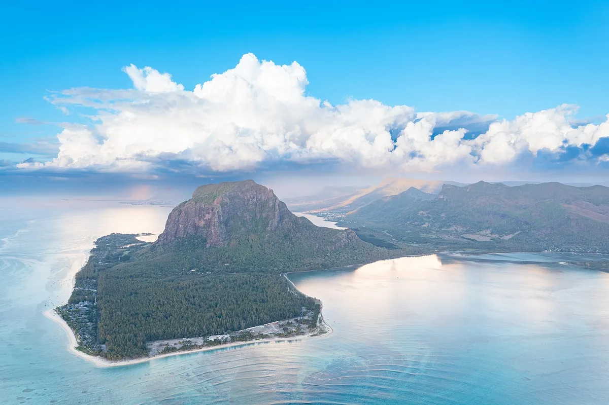 Aerial view of the Le Morne Brabant mountain and peninsula ringed by a pale turquoise lagoon in southwest Mauritius