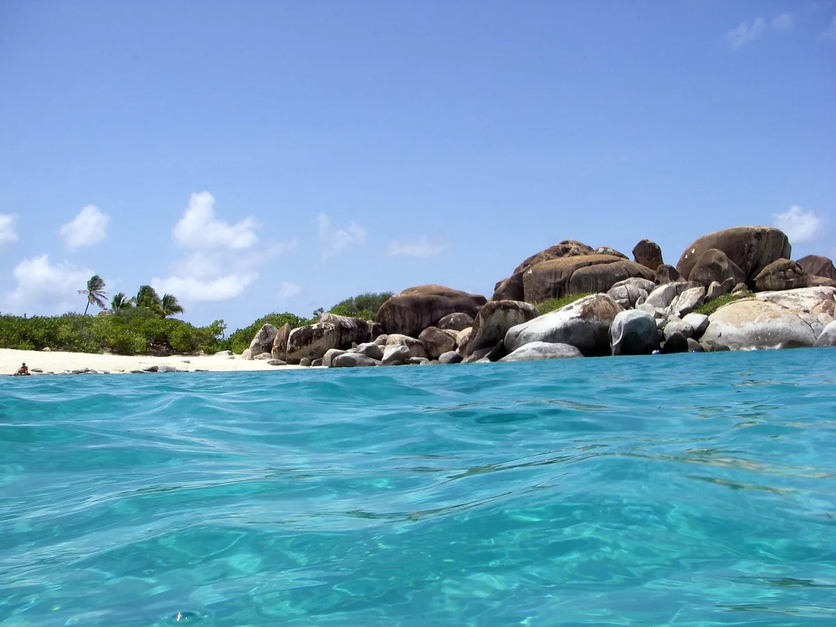 Giant granite boulders on the beach at The Baths on Virgin Gorda, seen from the clear turquoise water